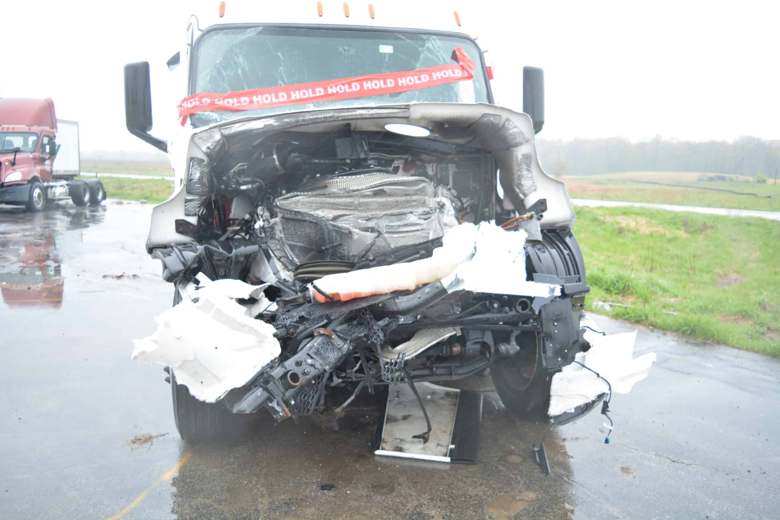 A smashed front end of a semi-truck cab after a high speed head-on truck accident.